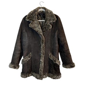 May include: A brown faux fur lined suede coat with a button closure and two pockets. The coat has a collar made of faux fur.