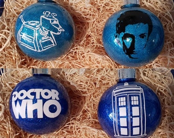 May include: Six round Christmas ornaments with a Doctor Who theme. The ornaments are blue and silver with glitter. The ornaments feature the Doctor, the TARDIS, and Daleks.