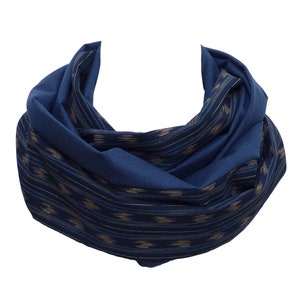 Könnte beinhalten: Ein blauer gemusterter Schal mit geometrischem Design. Der Schal ist in der Mitte gefaltet und hat eine weiche, fließende Textur.