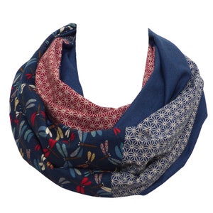 Könnte beinhalten: Blauer Loop-Schal mit Patchwork-Design. Der Schal hat Abschnitte aus einfarbigem blauem Stoff, Libellenmuster, geometrischen Mustern und einem bordeauxfarbenen Blumenmuster. Der Schal ist aus weichem Stoff.