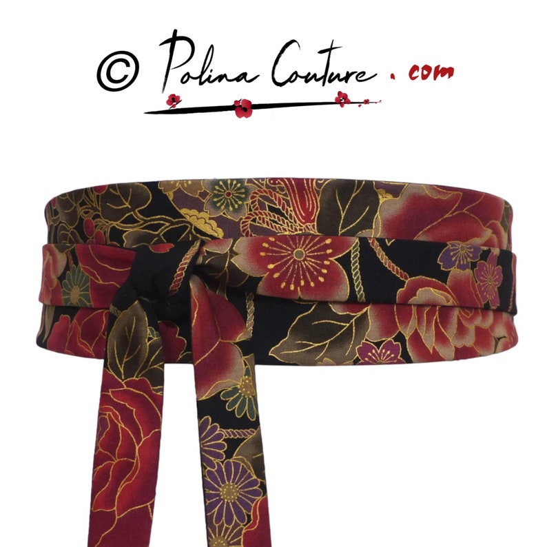 May include: A black fabric belt with a red, gold, and purple floral pattern. The belt is tied in a bow at the front. The text "Polina Couture .com" is visible in the top left corner of the image.