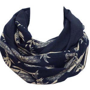 Könnte beinhalten: Ein marineblauer Schal mit einem weißen Blumenmuster. Das Muster zeigt stilisierte Bambuspflanzen und Blumen.