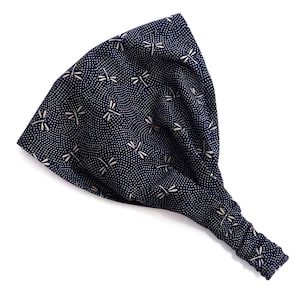 May include: A navy blue headband with a white dragonfly pattern. The headband is wide and has a gathered section at the back. The fabric is covered in small white dots.