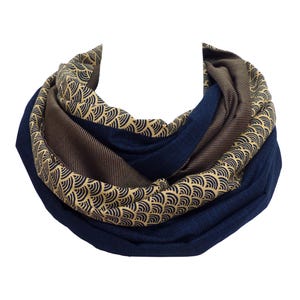 Könnte beinhalten: Ein dunkelblauer und brauner Infinity-Schal mit einem goldenen und schwarzen geometrischen Muster.