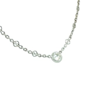 Op de afbeelding: Een delicate zilveren ketting met een enkele, ronde, heldere diamant hanger.
