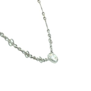 Op de afbeelding: Een delicate zilveren ketting met een enkele, heldere, ronde edelsteen hanger.