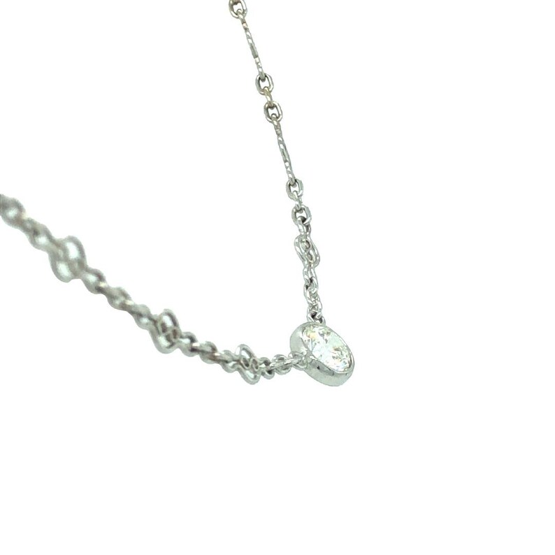 Op de afbeelding: Een delicate zilveren ketting met een enkele, heldere, ronde edelsteen hanger.