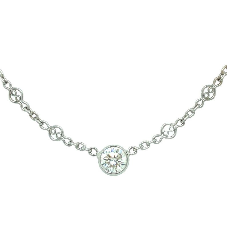 Op de afbeelding: Een delicate zilveren ketting met een ronde diamant hanger.