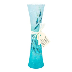 May include: A turquoise blue glass vase with a white and blue ombre effect. The vase is decorated with a pattern of small blue fish swimming upwards. The vase is tied with a white ribbon and a tag that reads "Strawsilk on Glass by Karen Ross - not intended for food or drink - a unique gift for someone special - strawsilk.com.au".