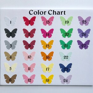 May include: A colour chart displaying 27 paper butterfly cutouts in a range of colours, arranged on a white background. The butterflies are numbered and the text "Color Chart" is visible. Colours include white, black, red, pink, and yellow.