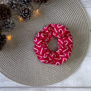 May include: Red scrunchie with a white candy cane pattern.