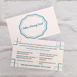 May include: A white rectangular Celiac Dining Card with blue and gray text. The front features a scalloped blue border and the title. The back lists gluten sources, safe items, and cross-contamination warnings, including the text: Deep Fryers Don't kill gluten. This is a myth!