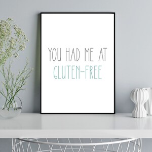Pu&ograve; includere: Una stampa incorniciata nera con sfondo bianco e il testo "You had me at gluten-free" in nero e turchese.