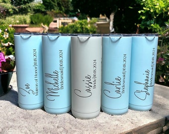 May include: Five personalized stainless steel tumblers with names and titles, including "Matron of Honor", "Bridesmaid", and "Bride". The tumblers are light blue and gray.