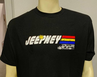 May include: Black t-shirt with a white graphic of a jeepney, a public transportation vehicle in the Philippines, with a yellow sun and red, yellow, and blue stripes.