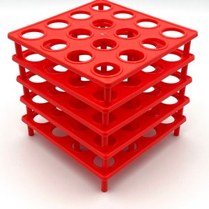 May include: A red plastic test tube rack with four tiers, each tier has 16 circular holes for holding test tubes.