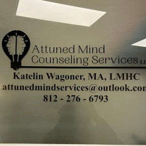 May include: A black and white image of a lightbulb with a brain inside. The text "Attuned Mind Counselling Services LLC" is below the image. The text "Katelin Wagoner, MA, LMHC" is below the text. The text "attunedmindservices@outlook.com" is below the text. The text "812-276-6793" is below the text.