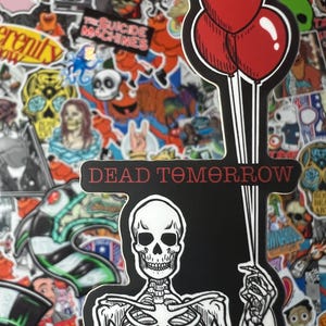 May include: A black and white sticker featuring a skeleton holding three red balloons. The text "DEAD TOMORROW" is above the skeleton. The background is a collage of various colorful stickers.