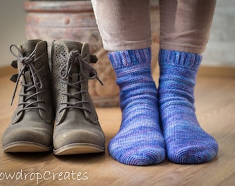 May include: A pair of brown leather boots with laces and a pair of blue and purple striped socks.