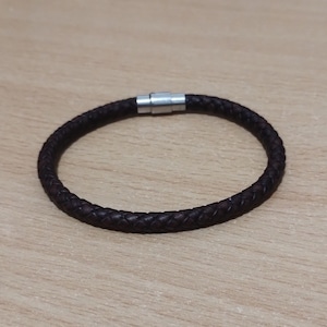 May include: A brown leather bracelet with a silver magnetic clasp.