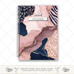May include: A teacher's academic diary with a patterned cover. The design combines pink, navy, and gold elements, including leopard print and geometric shapes. The text "2026/2027" and "Mrs Jenna Marsden" are displayed on the cover.
