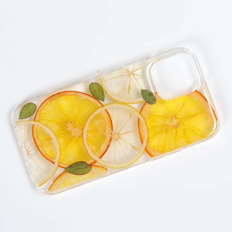 Clear resin phone case with dried lemon and orange slices, leaves on it.