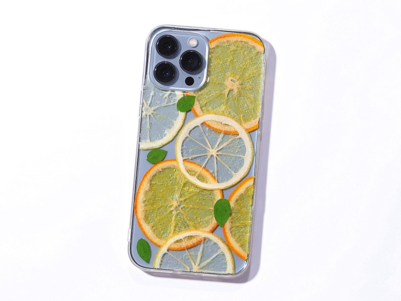 Clear resin phone case with lemon and orange slices, leaves is on the sierra blue iphone 13 pro max.