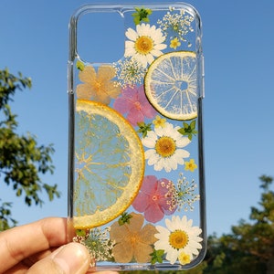 Handcrafted transparent phone case with pressed citrus slices and wildflowers on a clear background, ideal for those seeking a unique, nature-inspired accessory for their device.