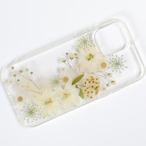 Minimalist clear phone case featuring an arrangement of pressed wildflowers, capturing the simplicity and beauty of SunnyPigStudio's creations.