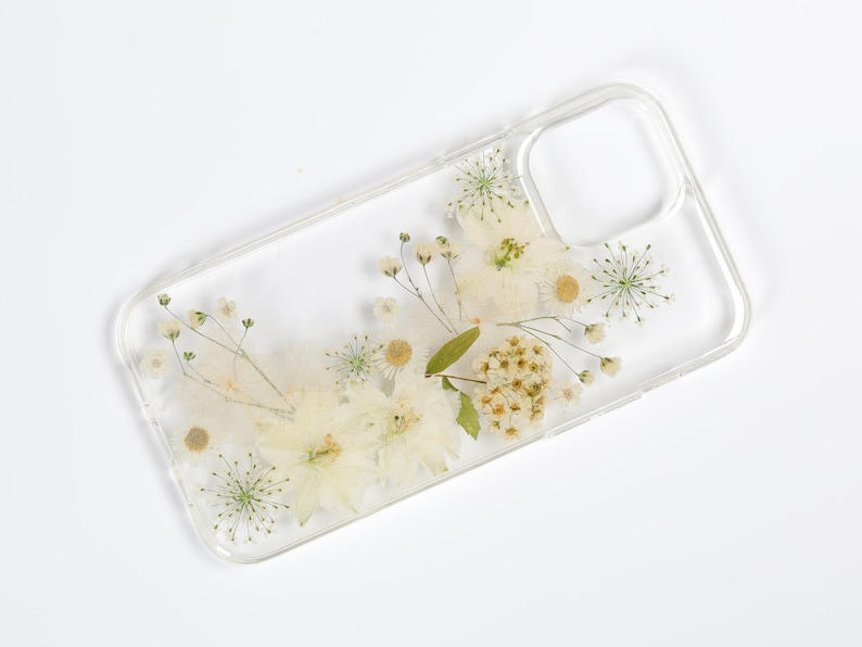 Minimalist clear phone case featuring an arrangement of pressed wildflowers, capturing the simplicity and beauty of SunnyPigStudio's creations.