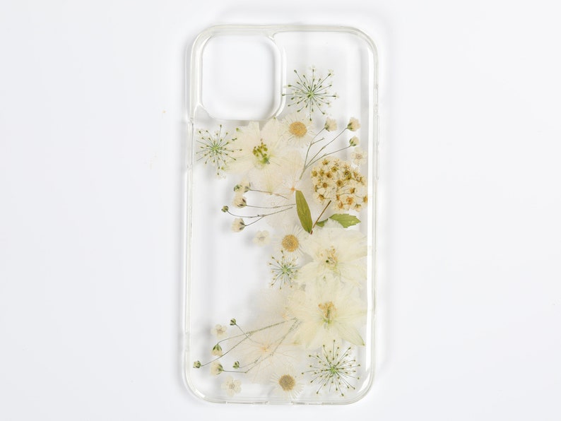 Neutral-toned clear phone case with a botanical pressed flower arrangement, reflecting SunnyPigStudio's commitment to organic aesthetics.