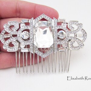 May include: Silver hair comb with a large clear crystal and smaller crystals in a geometric design.