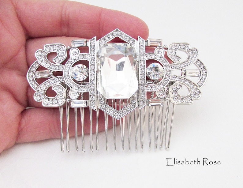 May include: Silver hair comb with a large clear crystal and smaller crystals in a geometric design.