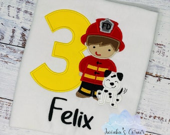 May include: A white t-shirt with a yellow number 3, a cartoon firefighter holding a dalmatian puppy, and the name "Felix" in black text.