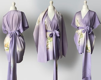 May include: A lavender silk robe with a floral print and a long sash tie. The robe has short sleeves and a V-neckline.