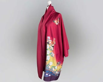 May include: A red kimono with a gradient design featuring butterflies and flowers. The kimono has a long, flowing silhouette and is made of a soft, lightweight fabric.