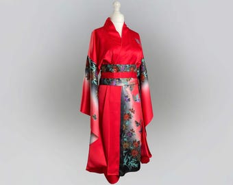 May include: A red kimono with a floral pattern and a black obi belt. The kimono has long sleeves and a wide, flowing skirt.