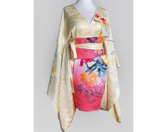 May include: A yellow and pink kimono with a floral print. The kimono has long sleeves and a wrap closure. The fabric is silky and has a subtle sheen.