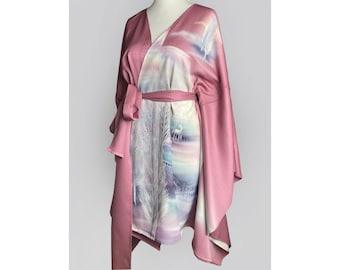 May include: A pink and white silk kimono with a nature-inspired print featuring trees and a deer. The kimono has a wrap-around style with a sash tie.