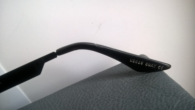 May include: Black plastic sunglasses with the text "V2016 ONAX CE" printed on the arm.