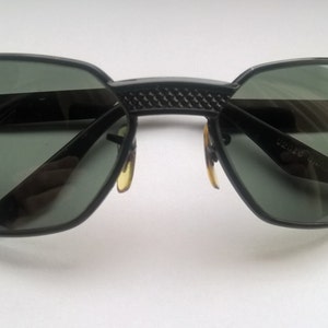May include: Black sunglasses with a textured bridge and dark lenses.