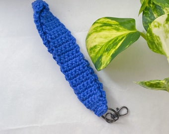 May include: A blue crocheted keychain with a silver metal key ring.