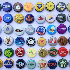 May include: A collection of 36 colourful bottle caps with various logos and designs. The caps are arranged in a grid pattern on a white background. Some of the logos include Bud Light, Miller High Life, Coors Light, and Pabst Blue Ribbon.