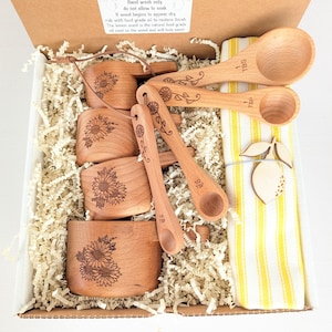 Set de regalo para repostería con diseño de girasoles, ideal para el Día de la Madre, con tazas y cucharas medidoras.
