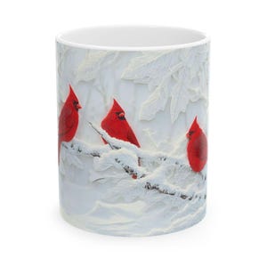 Taza de café navideña con cardenales en la nieve invernal. Diseño festivo para amantes de los pájaros rojos.