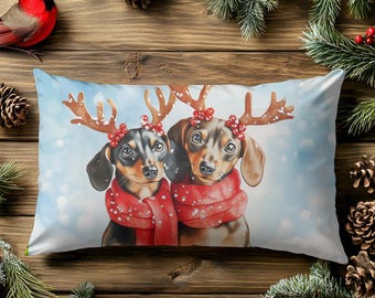 Può includere: Un cuscino rettangolare decorativo con due bassotti che indossano corna di renna e sciarpe rosse. I cani sono ambientati su uno sfondo azzurro chiaro con effetto neve. A tema natalizio.