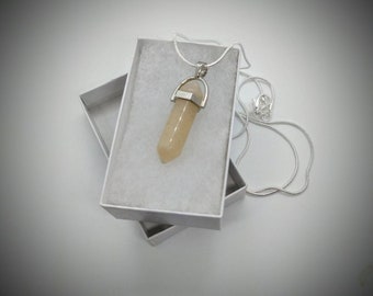 May include: A pale yellow crystal pendant on a silver chain in a white gift box. The crystal is shaped like a point and has a silver cap at the top.