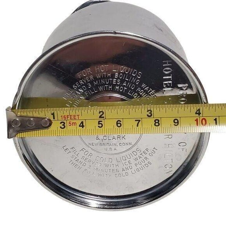 K&ouml;nnte beinhalten: Eine Vintage-Thermoskanne aus silberfarbenem Metall mit Schraubverschluss. Der Deckel tr&auml;gt die gepr&auml;gten Texte &bdquo;FOR HOT LIQUIDS&ldquo; und &bdquo;FOR COLD LIQUIDS&ldquo;. Der Durchmesser des Deckels betr&auml;gt ca. 10 cm.