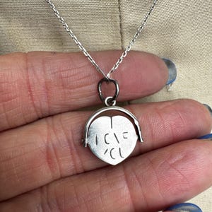 May include: A silver necklace with a heart-shaped pendant. The pendant has the words "I LOVE U" engraved on it. The necklace is on a silver chain.