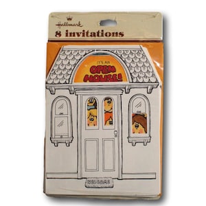 May include: A pack of Hallmark "8 Invitations" cards. The front of the pack shows a cartoon house with the text "IT'S AN OPEN HOUSE!" above the door. The house is white with black outlines and has a welcome mat.